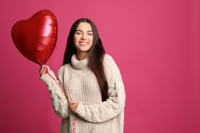 Photo of Portrait of young woman with heart shaped balloon on color background. Space for text