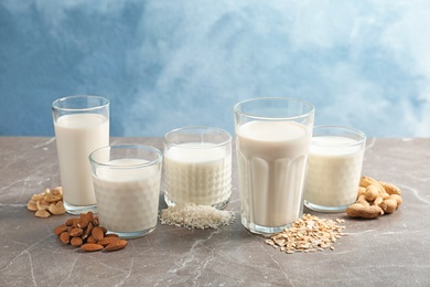 Photo of Glasses with different types of milk on table