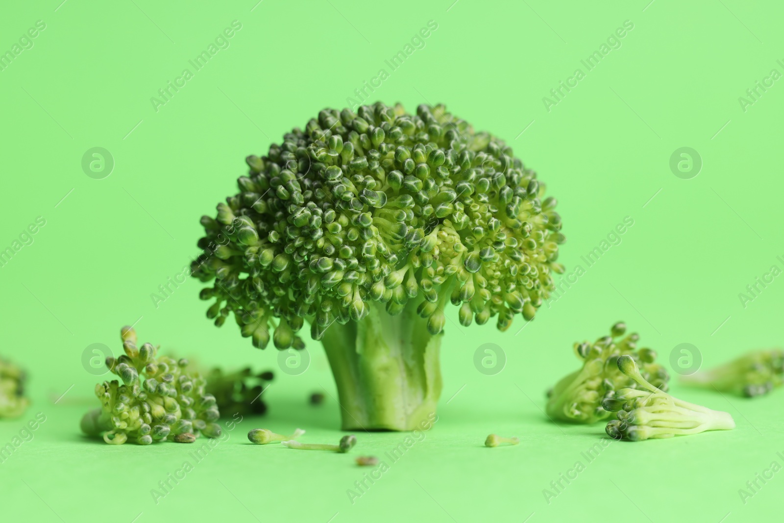 Photo of Fresh raw broccoli on light green background