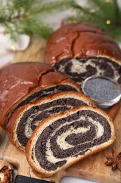 Cut poppy seed roll on wooden table, closeup. Tasty cake