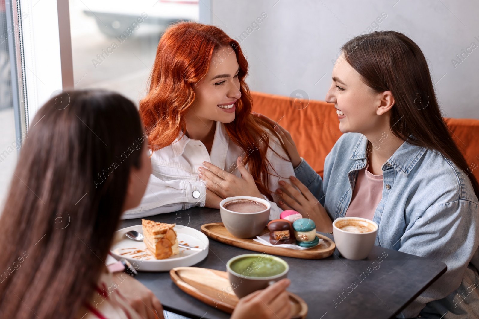 Photo of Happy friends spending time together in cafe