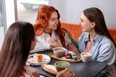 Photo of Happy friends spending time together in cafe