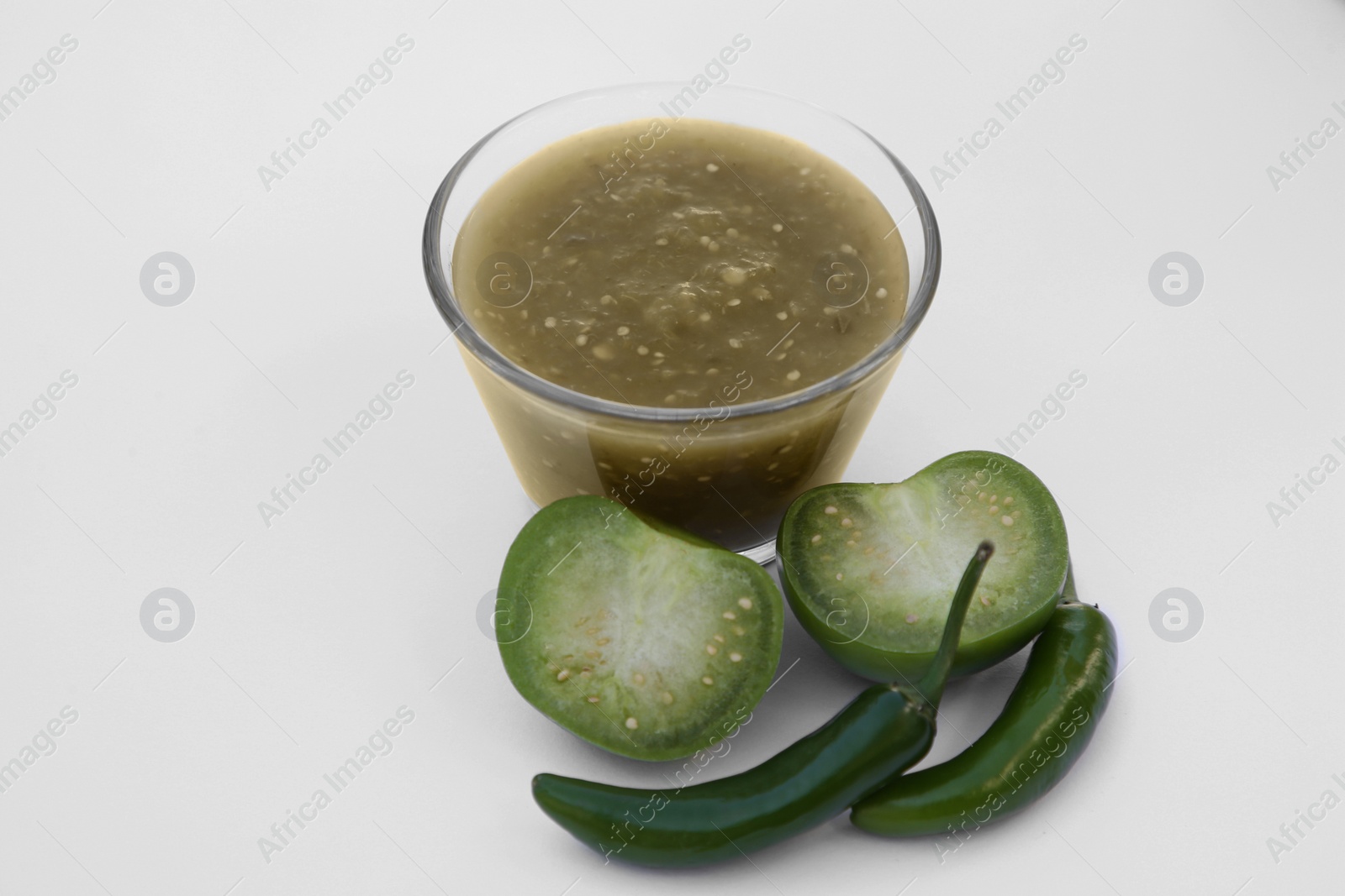 Photo of Delicious salsa sauce and ingredients on white background