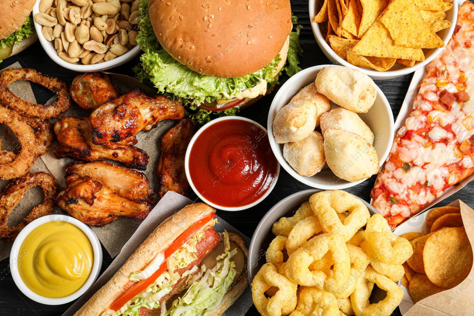 Photo of Burger, onion rings and other fast food as background, top view