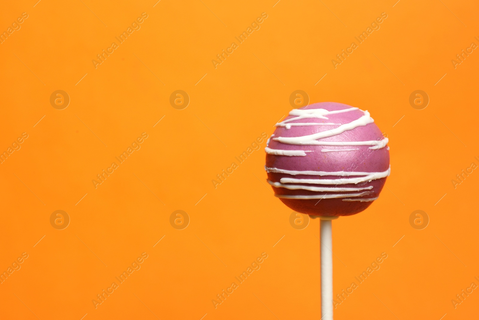 Photo of Bright delicious cake pop on color background. Space for text