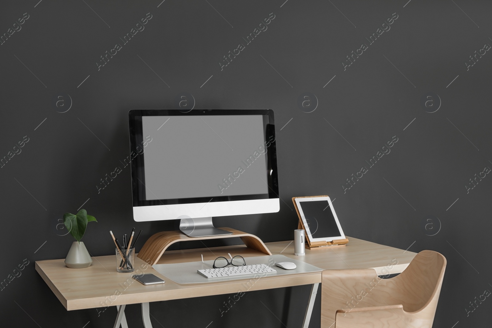 Photo of Modern workplace interior with computer and devices on table. Space for text