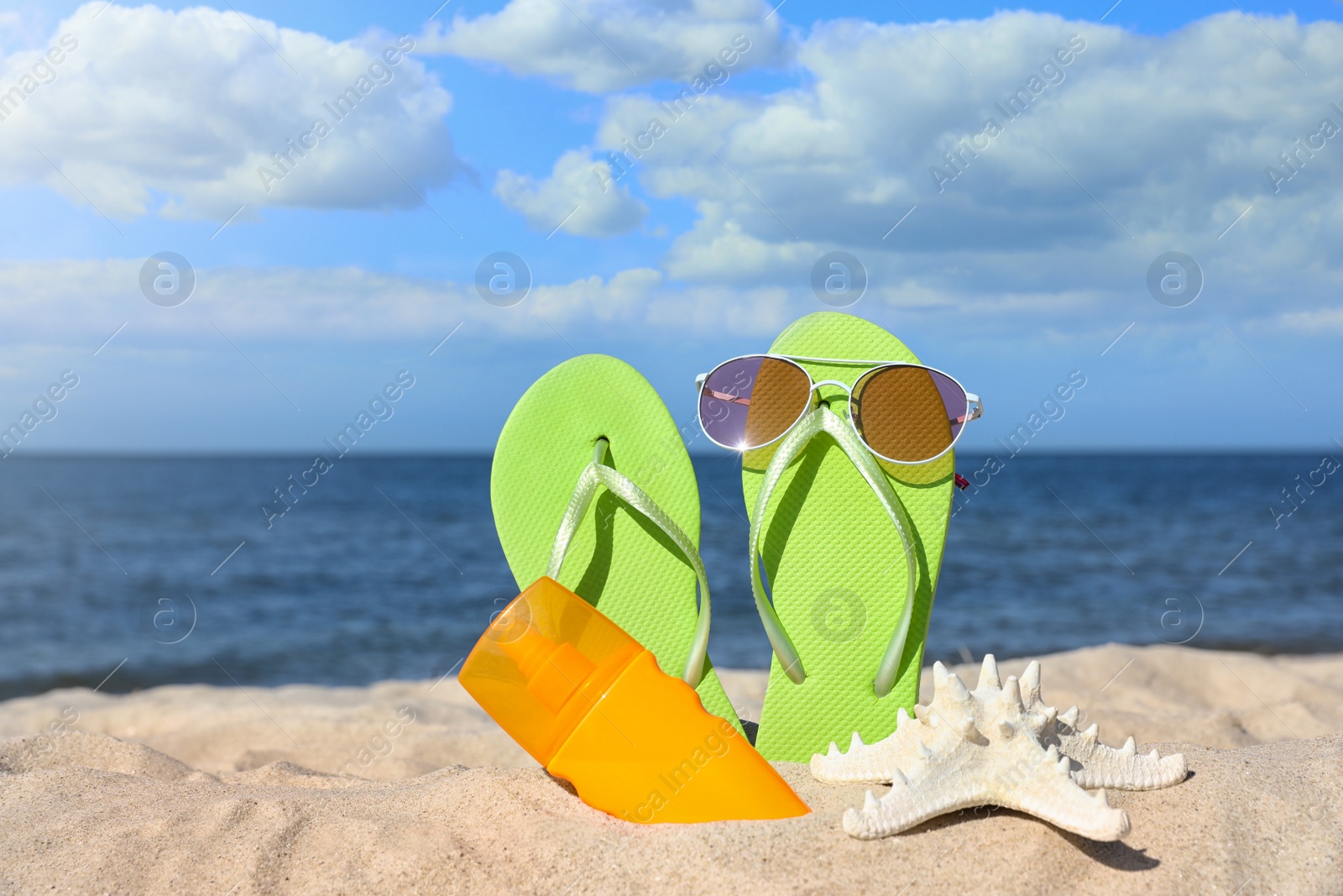 Photo of Composition with beach accessories on sand near sea in summer