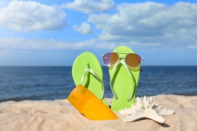 Photo of Composition with beach accessories on sand near sea in summer