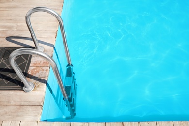 Modern swimming pool with step ladder outdoors