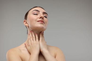 Photo of Beautiful woman touching her neck on grey background. Space for text