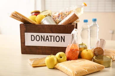 Photo of Donation box and different products on table indoors