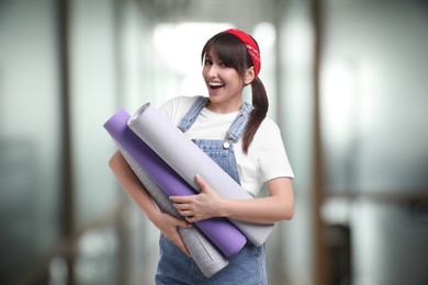 Image of Woman with wallpaper rolls on blurred background