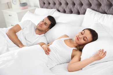 Photo of Lovely couple sleeping in large comfortable bed