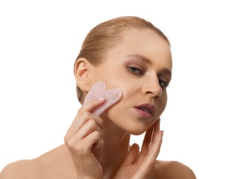 Photo of Beautiful young woman doing facial massage with gua sha tool on white background, closeup