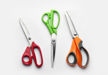 Photo of Set of different scissors on white background, top view