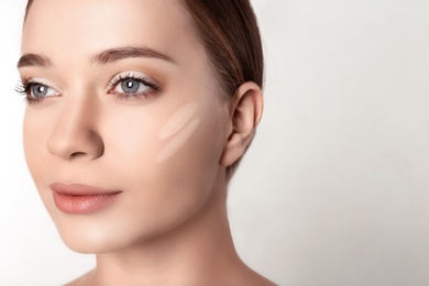 Photo of Portrait of beautiful young woman with makeup smears on face against white background