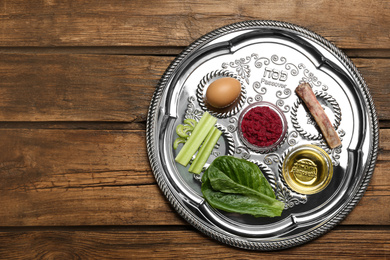 Photo of Passover Seder plate (keara) on wooden table, top view with space for text. Pesah celebration