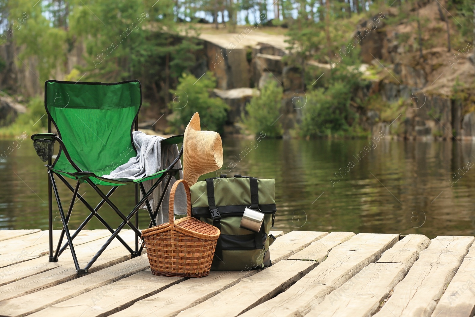 Photo of Set of camping equipment on wooden pier near lake