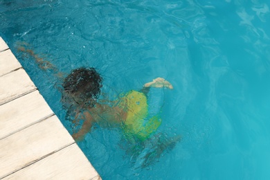 Photo of Little child in outdoor swimming pool. Dangerous situation