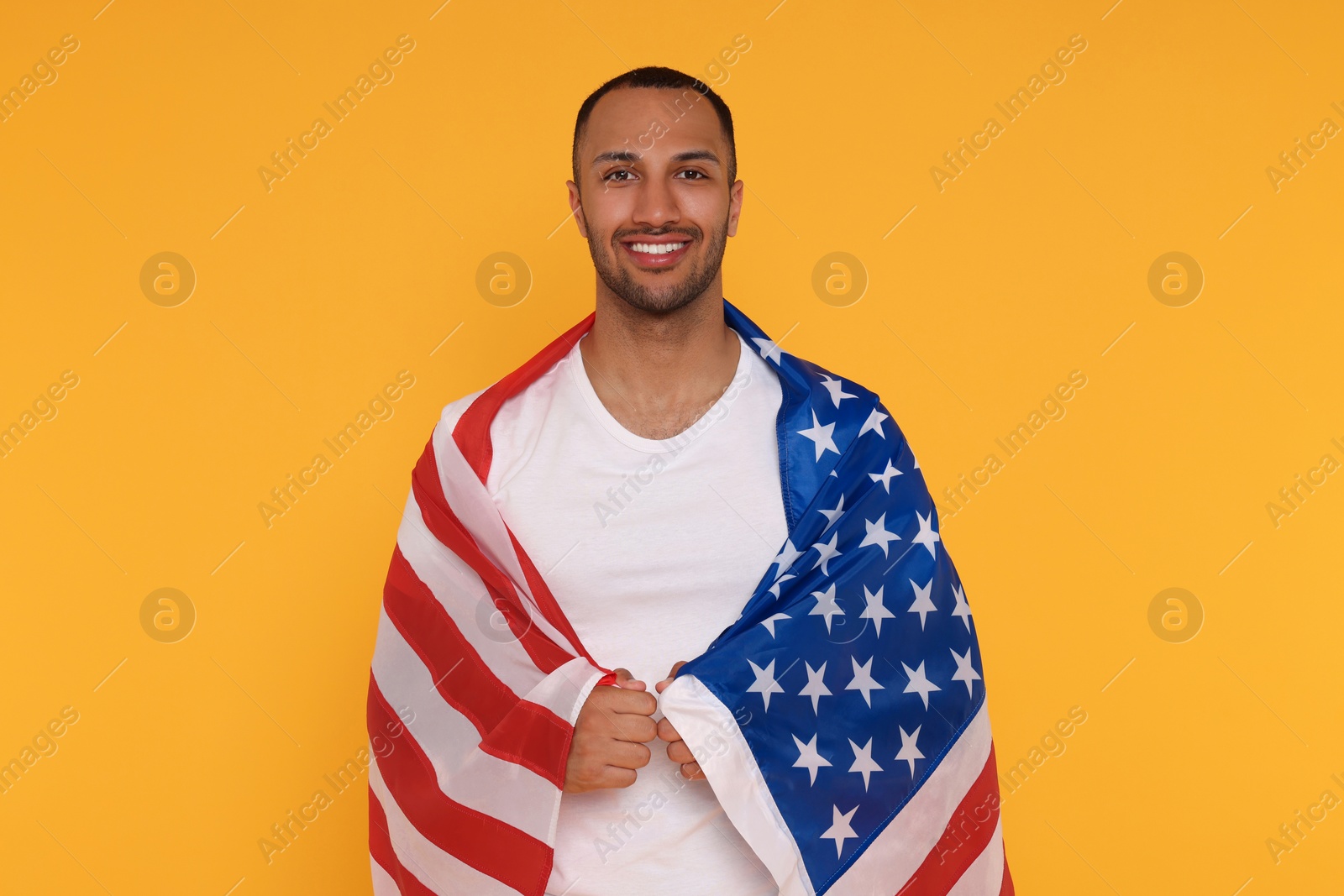 Photo of 4th of July - Independence Day of USA. Happy man with American flag on yellow background