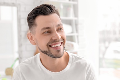 Photo of Young man with beautiful smile indoors. Teeth whitening