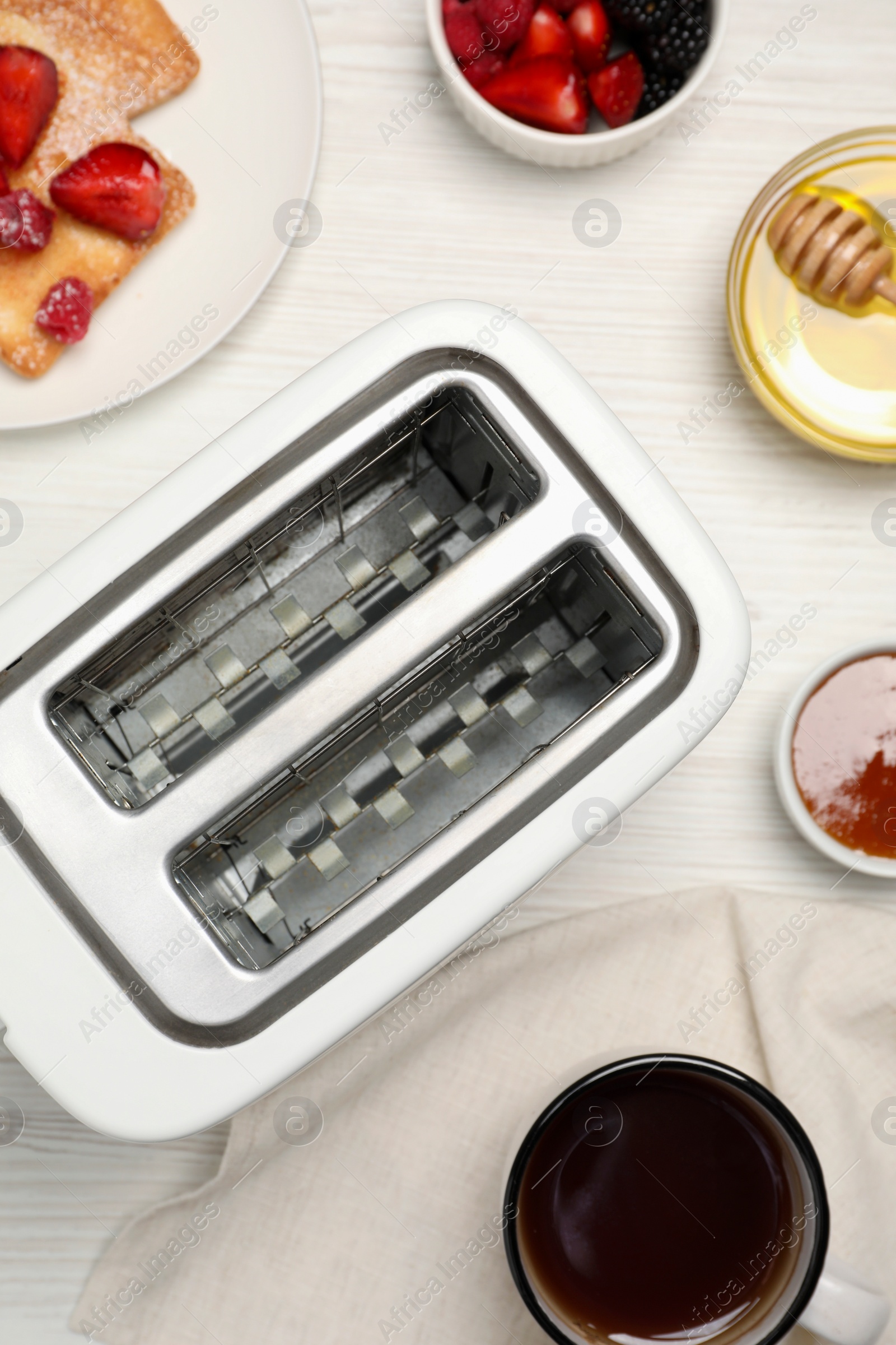 Photo of Flat lay composition with modern toaster on white wooden table