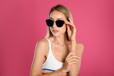 Photo of Beautiful woman in stylish sunglasses on pink background