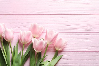 Photo of Beautiful tulips for Mother's Day on wooden background, top view