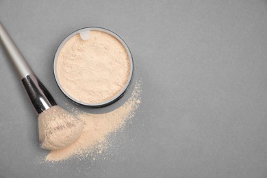 Photo of Loose face powder and makeup brush on light grey background, flat lay. Space for text
