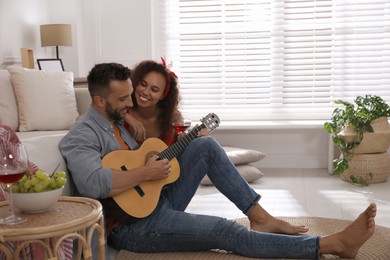 Photo of Lovely couple with guitar spending time together at home