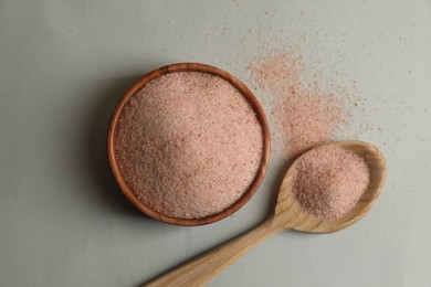 Photo of Himalayan salt in bowl and spoon on grey background, flat lay