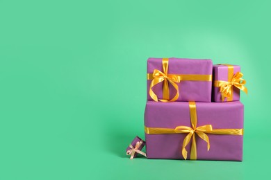 Photo of Beautifully wrapped gift boxes on green background. Space for text