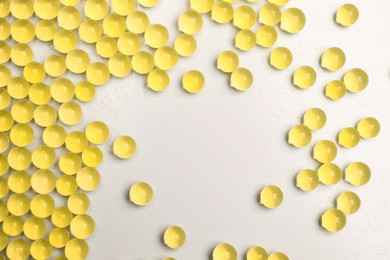 Photo of Yellow vase filler on light background, flat lay. Water beads
