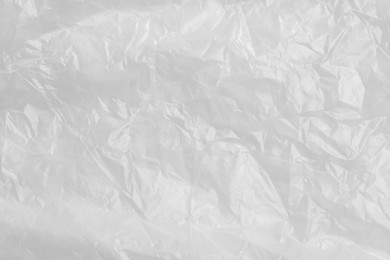 Photo of Crumpled transparent plastic bag as background, top view