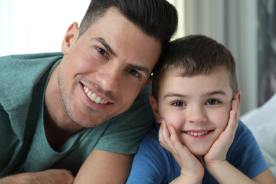 Photo of Dad and son spending time together at home, closeup. Happy Father's Day