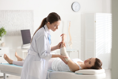 Photo of Female orthopedist examining patient's arm in clinic