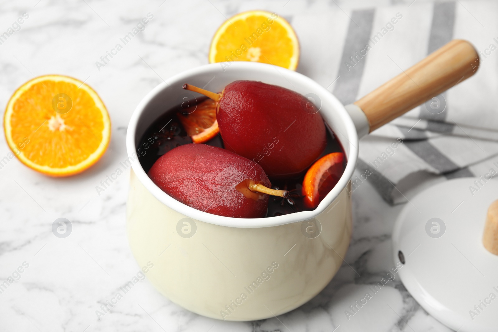 Image of Poaching pears in mulled wine on white marble table