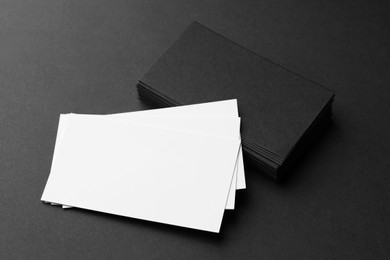 Photo of Blank business cards on black background, closeup. Mockup for design