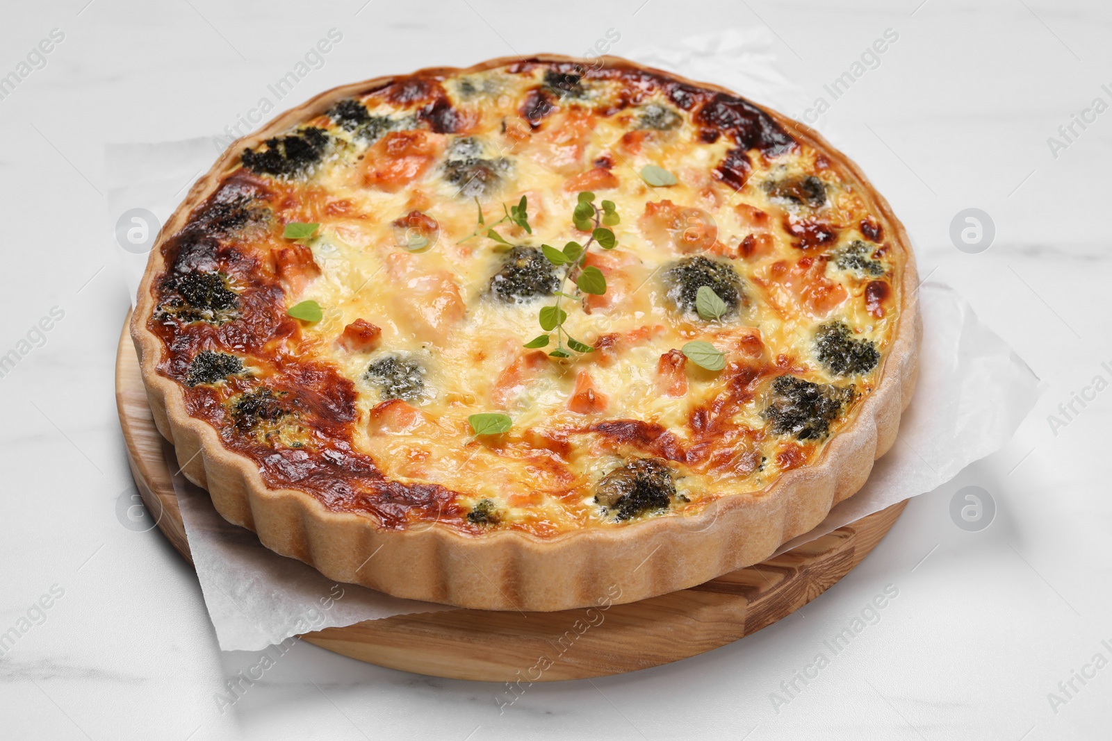 Photo of Delicious homemade quiche with salmon and broccoli on white table