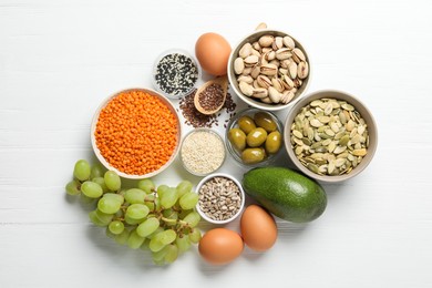 Photo of Different products high in natural fats on white wooden table, flat lay