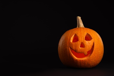 Photo of Pumpkin head on black background, space for text. Jack lantern - traditional Halloween decor