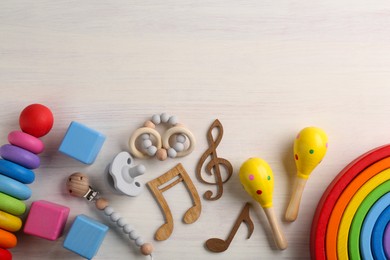 Photo of Baby song concept. Wooden notes, kids maracas and toys on table, flat lay. Space for text