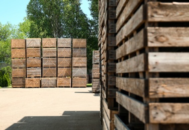 Photo of Old empty wooden crates outdoors on sunny day. Space for text