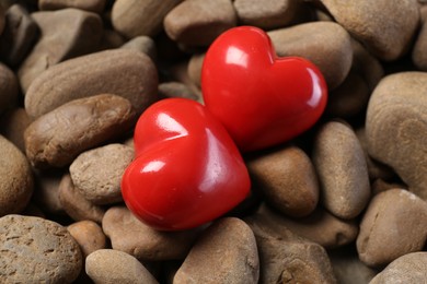 Photo of Red decorative hearts on stones, closeup view