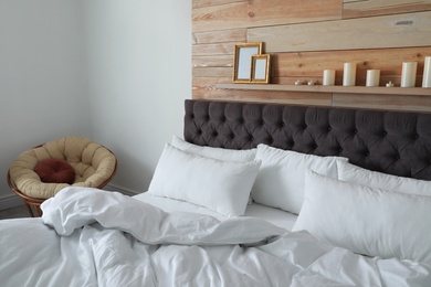 Photo of Large comfortable bed in stylish room. Modern interior design