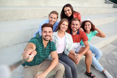 Photo of Happy young people taking selfie on stairs outdoors