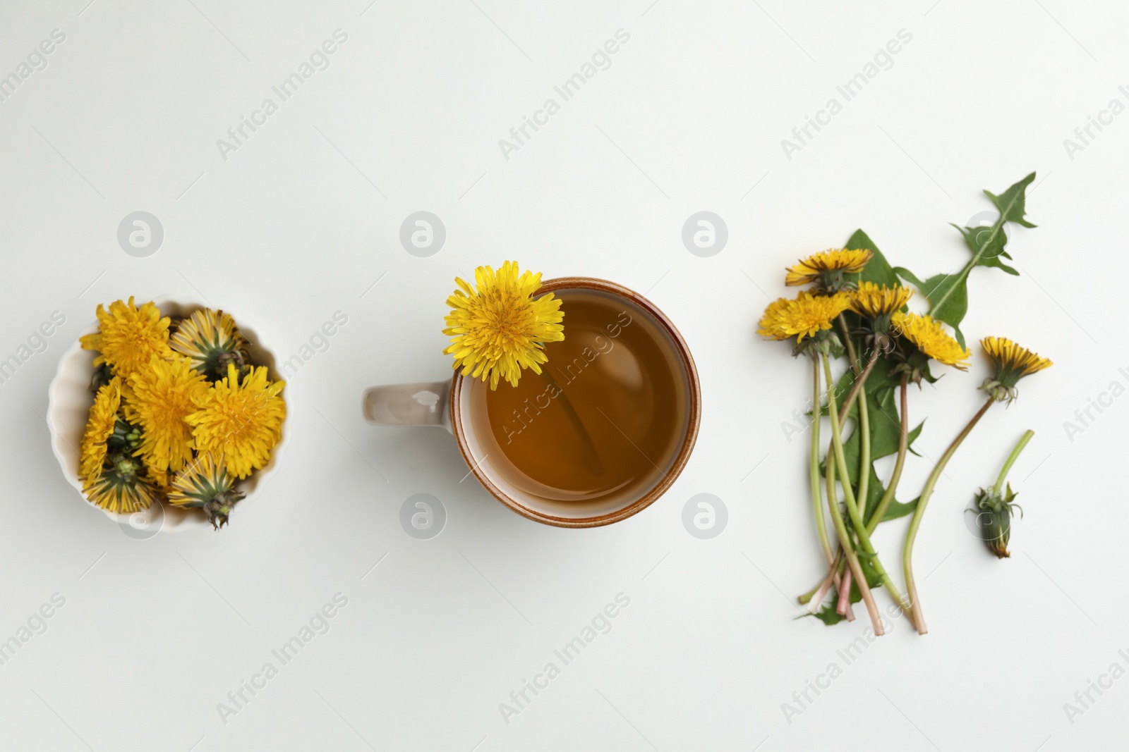 Photo of Delicious fresh tea and beautiful dandelion flowers on white background, top view