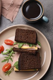 Photo of Delicious sandwiches with boiled sausage, tomato, cheese and arugula on grey table, flat lay