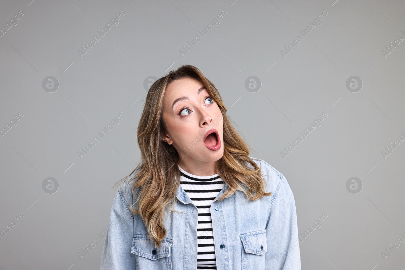 Photo of Portrait of surprised woman on grey background