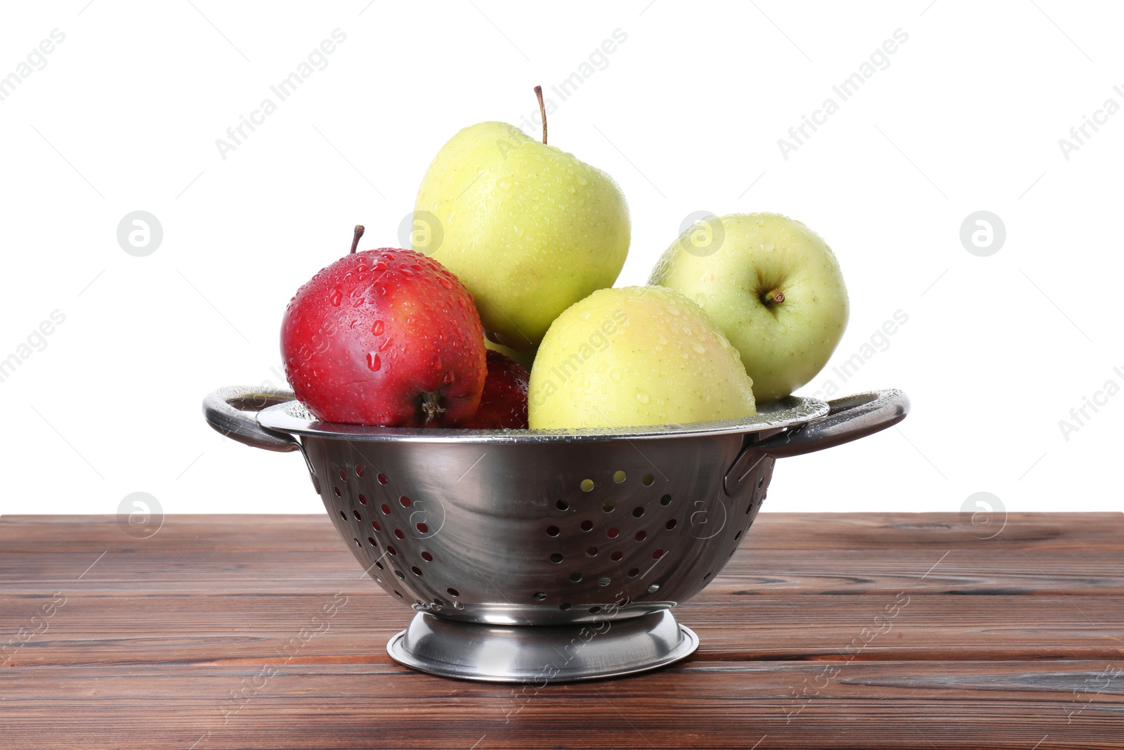 Photo of Metal colander with fresh apples on wooden table against white background